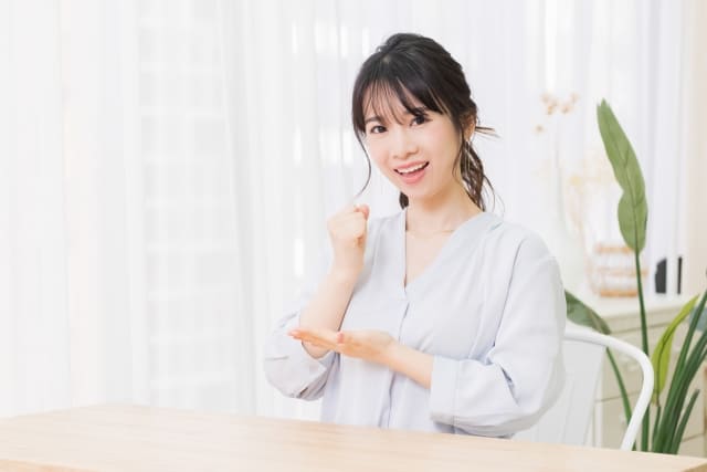 部屋で納得のジェスチャーをする若い女性