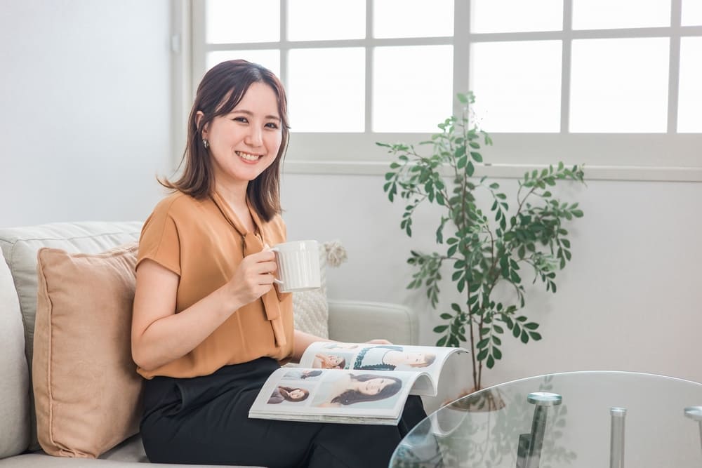 家でファッション雑誌を見るくつろぐ女性