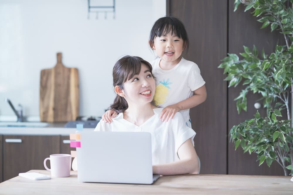 子供と遊びながらテレワークをする女性